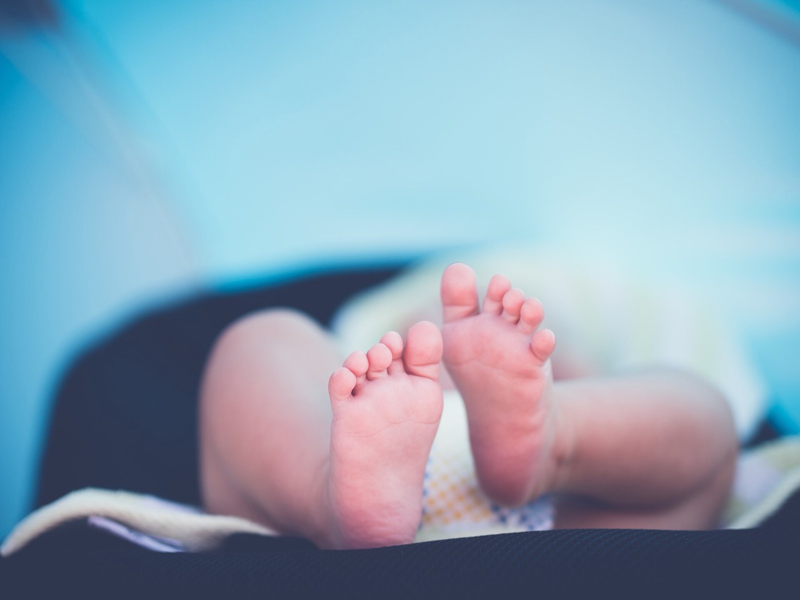 I piedi di un neonato appoggiati su una copertina