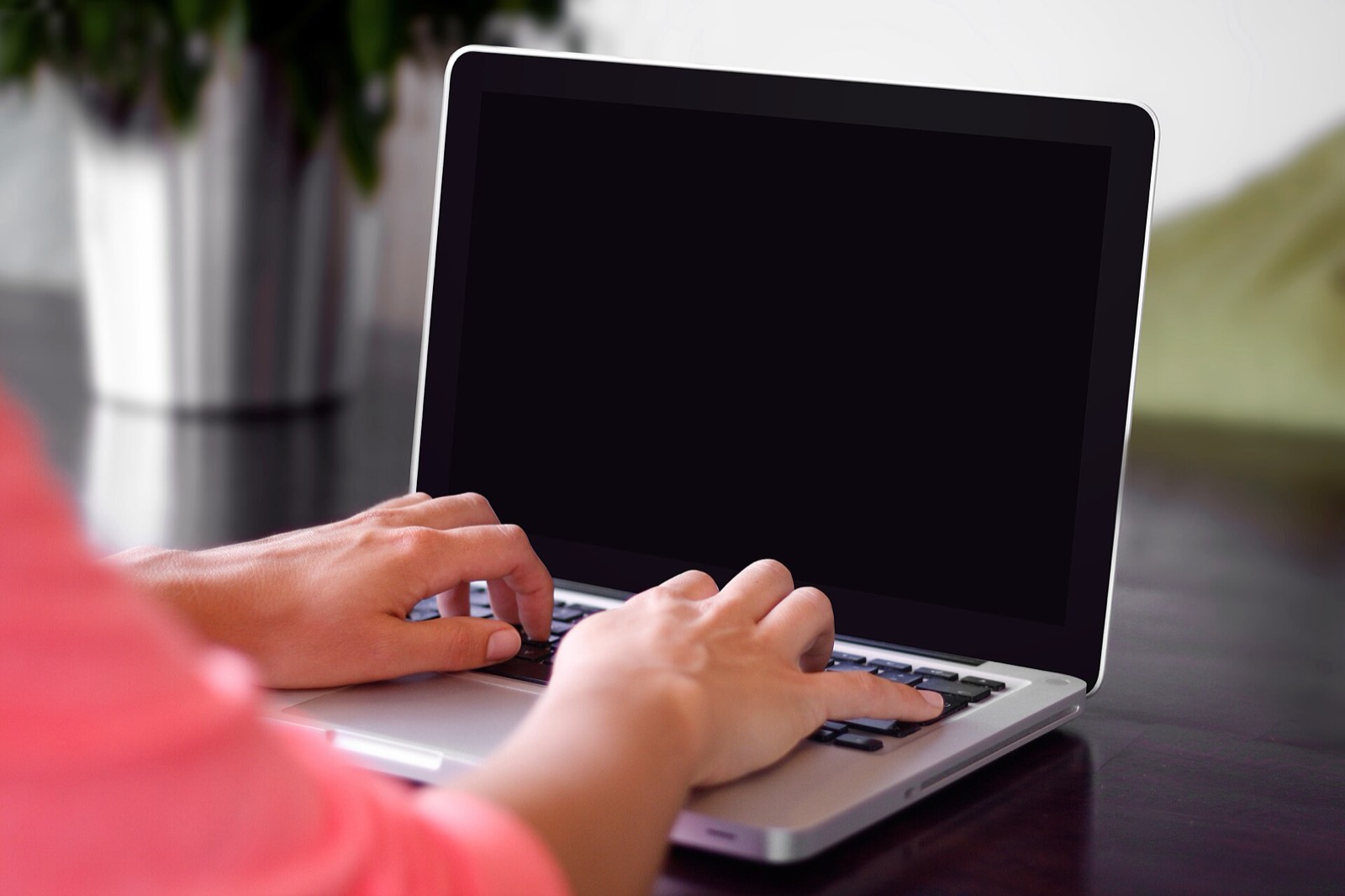 Due mani scrivono sulla tastiera di un computer portatile