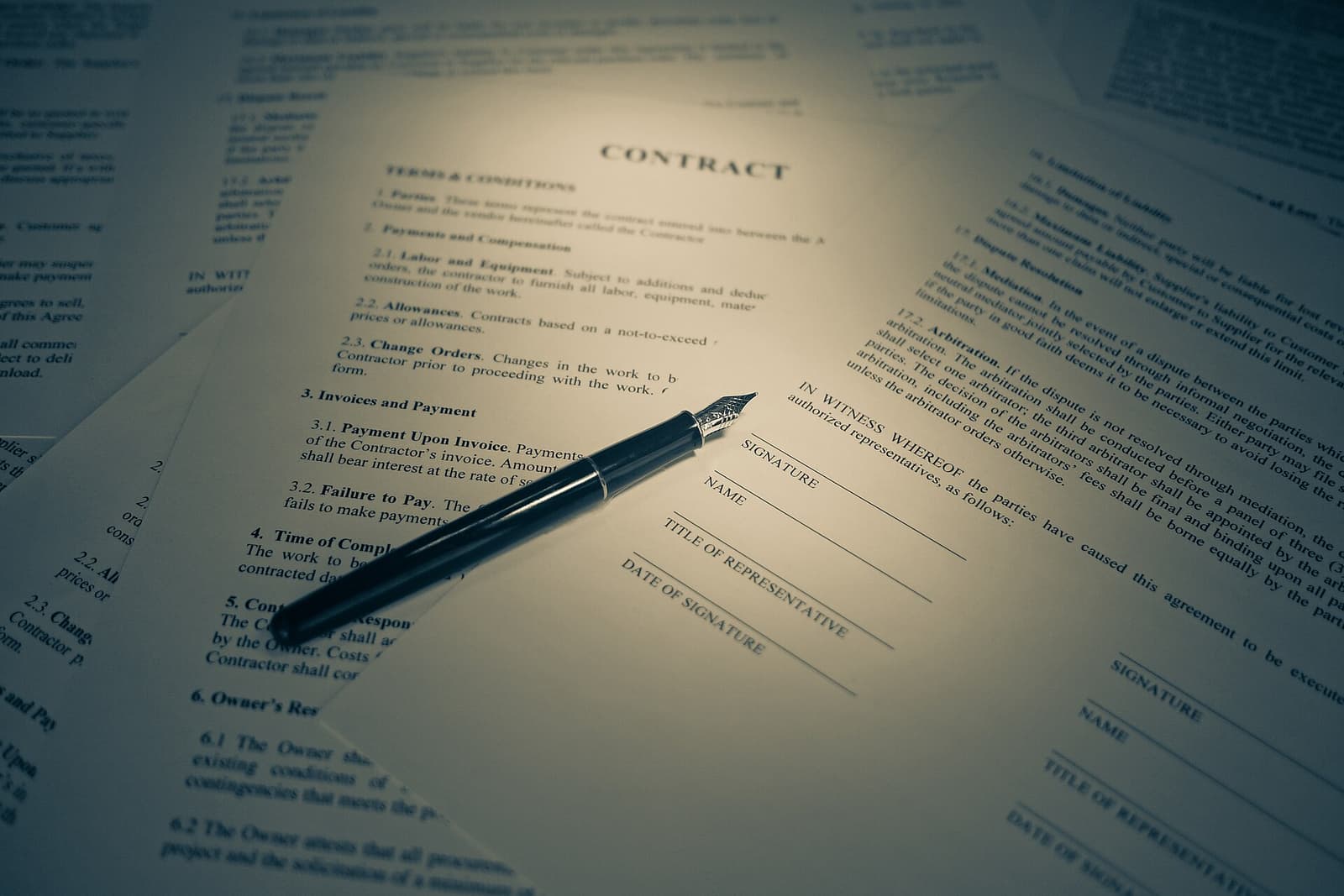 Una mano firma un documento su una scrivania